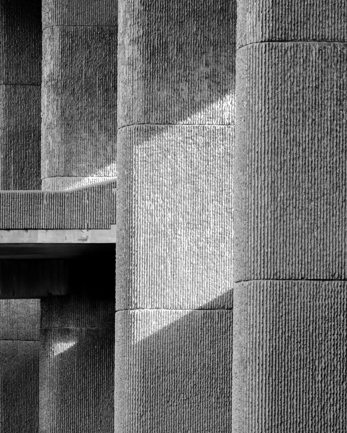 Ribbed concrete columns in raking light, in black and white